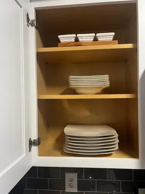 a cupboard with a stack of plates and dishes at Cozy Luxurious Spacious Apt with Valley View, Attached Garage,Pool,24-Hour Gym, 3 TV in Mission Viejo