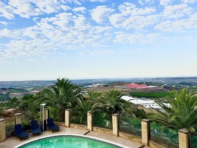 a swimming pool with blue chairs and palm trees at Vintoca Luxury Honeymoon Suite Farm Retreat in Oceanside