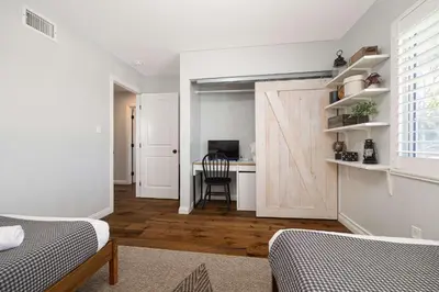 a bedroom with a sliding barn door with a desk at 10 min to Beach Central Villa in San Diego