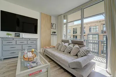 a living room with a couch and a flat screen tv at Gaslamp District Heart of San Diego in San Diego
