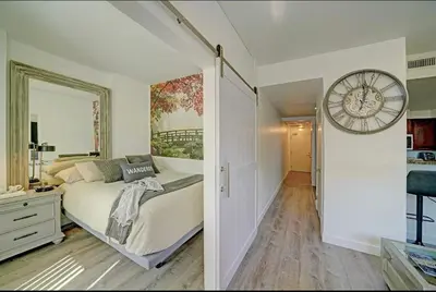 a bedroom with a bed and a large clock on the wall at Gaslamp District Heart of San Diego in San Diego
