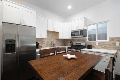 a kitchen with a wooden table and a stainless steel refrigerator at Ocean Views 2 Kitchen Living area Villa in San Diego