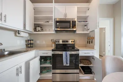 a kitchen with white cabinets and a stove at LUX Oasis North Park, King Beds, Workspaces, Parking in San Diego