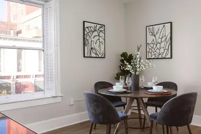 a dining room with a table and chairs and a window at The Historic Penn Hotel in San Diego