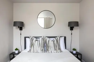 a bedroom with a bed with a mirror on the wall at The Historic Penn Hotel in San Diego