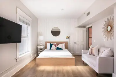 a bedroom with a bed and a couch at The Historic Penn Hotel in San Diego