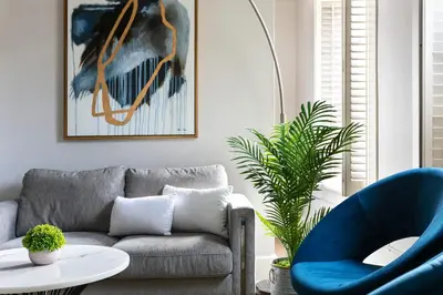 a living room with a couch and a blue chair at The Historic Penn Hotel in San Diego