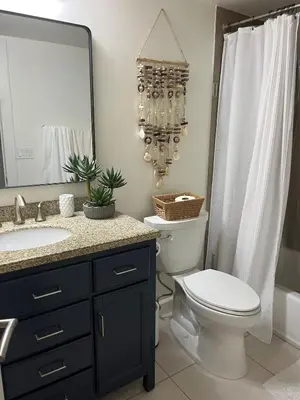 a bathroom with a toilet and a sink and a mirror at Sail Bay Condo in PB Bay View close to the Ocean! 30 day stay is required in San Diego