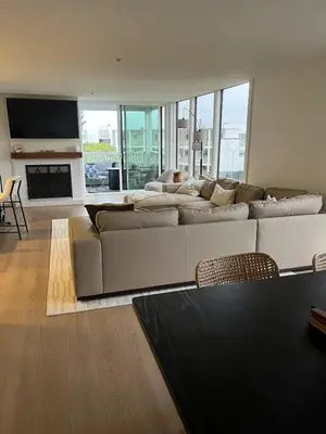 a living room with a large couch and a fireplace at Sail Bay Condo in PB Bay View close to the Ocean! 30 day stay is required in San Diego