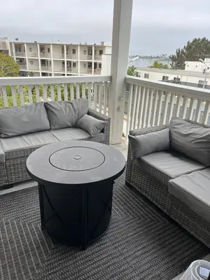 a patio with a couch and a table on a balcony at Sail Bay Condo in PB Bay View close to the Ocean! 30 day stay is required in San Diego