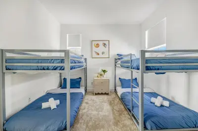 two bunk beds in a small room with blue pillows at Luxury Oasis Resort Pool&Spa Fitness Arcade in Ladera Ranch