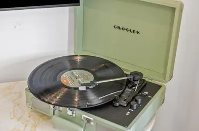 a record player with a cd in a green box at Luxury Resort Pool Spa Arcade Movie Gym in Mission Viejo