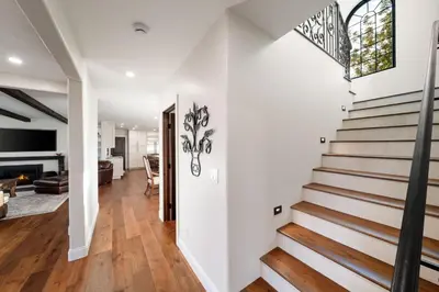 a staircase in a home with white walls and wood floors at Luxury Point Loma Retreat Pool Spa Views in San Diego