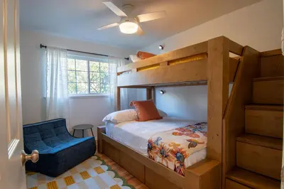 a bedroom with a bunk bed and a blue chair at Luxury Bayview Oasis • Pool Spa Games Views in San Diego