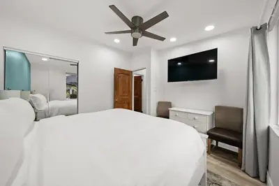 a white bedroom with a bed and a ceiling fan at 2br Pet-Friendly Oceanside Home in Oceanside