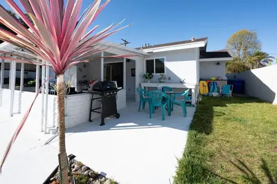 a palm tree in front of a house with a grill at Beach Home in Quiet Neighborhood 5 minutes from the Pier in Oceanside
