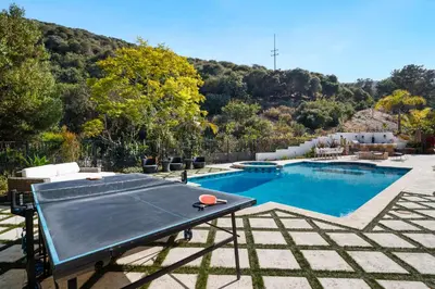 a ping pong table sitting next to a swimming pool at Elegant La Jolla Villa - Ocean Views & Pool in San Diego