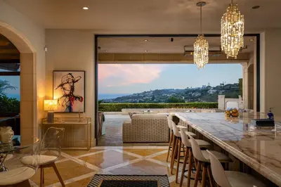 a dining room with a bar with chairs and a large window at Elegant La Jolla Villa - Ocean Views & Pool in San Diego