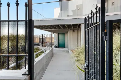 a walkway leading to a building with a green door at New Modern Studio - Stunning Ocean view in San Diego