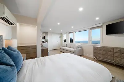 a bedroom with a large white bed and a couch at New Modern Studio - Stunning Ocean view in San Diego