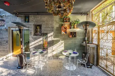 a dining room with two tables and chairs and a chandelier at Hotel Narcissus - Room 5 in San Diego