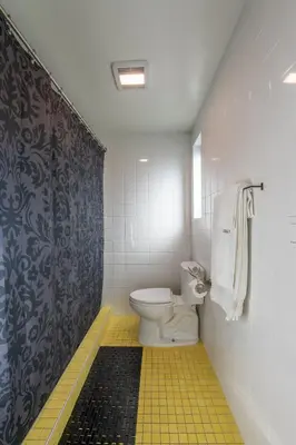 a bathroom with a toilet and a shower curtain at Hotel Narcissus - Room 5 in San Diego