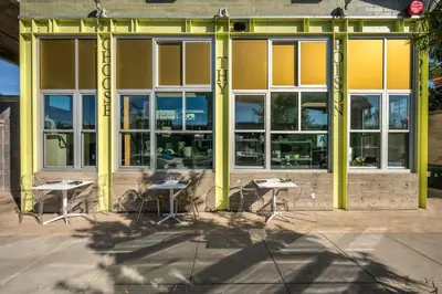 a group of tables and chairs in front of a building at Hotel Narcissus - Room 6 in San Diego