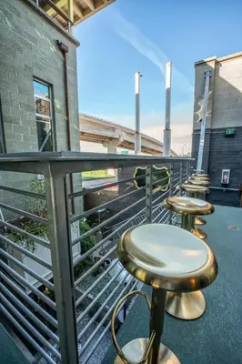 a row of tables and stools on a balcony at Hotel Narcissus - Room 6 in San Diego