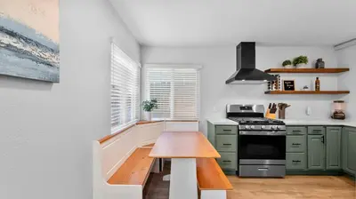 a kitchen with green cabinets and a wooden table at Stylish Apartments in Mission Hills with Outdoor Space in San Diego