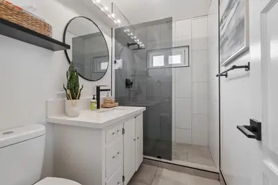 a white bathroom with a shower and a sink at NEW Cozy Modern Home with Hot Tub and Ocean Views in San Diego
