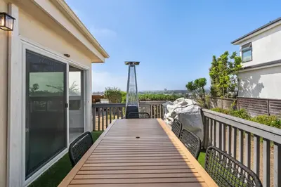 a wooden deck with chairs on a balcony at NEW Cozy Modern Home with Hot Tub and Ocean Views in San Diego