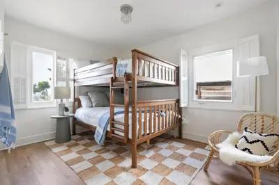 a bedroom with a bunk bed and a chair at NEW Cozy Modern Home with Hot Tub and Ocean Views in San Diego