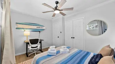 a bedroom with a bed with a ceiling fan and a desk at Chic San Diego Apartment with Hot Tub & Workspace in San Diego