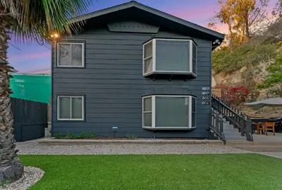 a black house with two windows and a patio at Chic San Diego Apartment with Hot Tub & Workspace in San Diego