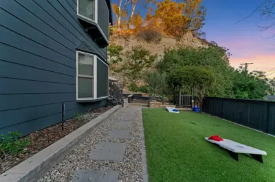 a yard with a house and a surfboard on the grass at Chic San Diego Apartment with Hot Tub & Workspace in San Diego