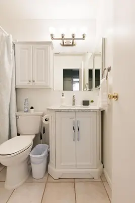 a white bathroom with a toilet and a sink at Relax and Recharge here Close to All Attractions in San Diego