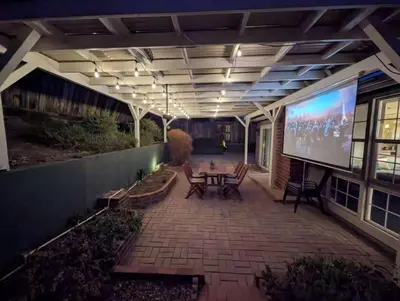a patio with a large screen on the side of a building at Relax and Recharge here Close to All Attractions in San Diego