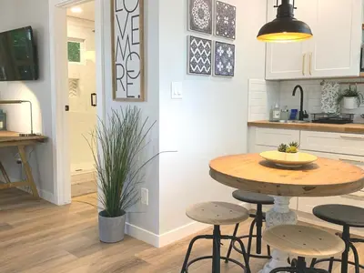 a kitchen with a table and stools in a kitchen at New cozy studio 2 queen beds kitchen walk to water! in San Diego