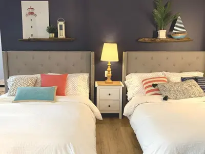 two beds sitting next to each other in a bedroom at New cozy studio 2 queen beds kitchen walk to water! in San Diego