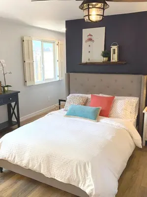 a bedroom with a large white bed with colorful pillows at New cozy studio 2 queen beds kitchen walk to water! in San Diego