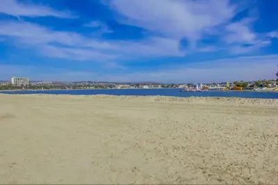 a sandy beach with a body of water in the background at Mission Bay Getaway - Walk to the Water in San Diego