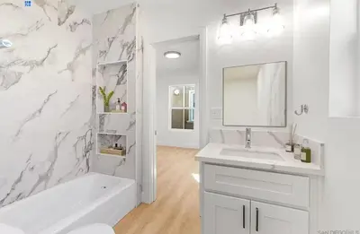 a white bathroom with a tub and a sink and a mirror at 2 Bedroom Modern North Park Gem in San Diego