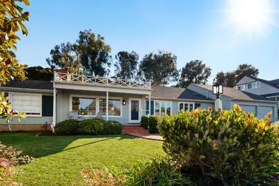 a house with a yard with grass and bushes at Coastal Elegance by the Shore in San Diego