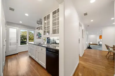a kitchen with white cabinets and a black dishwasher at Coastal Elegance by the Shore in San Diego