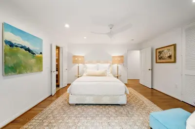 a white bedroom with a white bed and a rug at Coastal Elegance by the Shore in San Diego