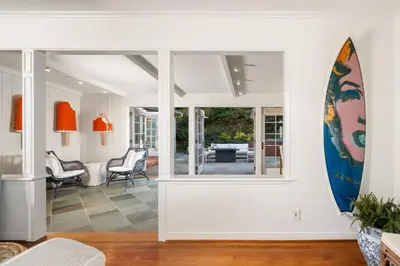 a living room with a surfboard on the wall at Coastal Elegance by the Shore in San Diego