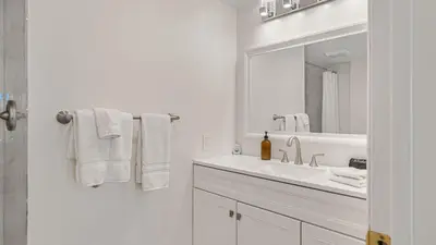 a white bathroom with a sink and a mirror at Resort-Style Estate w Pool Game Room Tennis Court Near Wineries The Tennis Ranch by AvantStay in Escondido