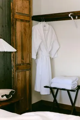 a white robe hanging on a wall next to a bed at Wild Moon Ranch with Pickleball, Cedar Tub, Views in Julian