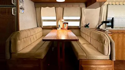 a table in the back of an rv with a couch at Retro Star-Wagon, Ocean Breez at Studios in Oceanside