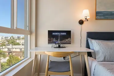 a desk in a room with a bed and a television at Luxury Living in N Park, 2BR, King Beds, Parking in San Diego